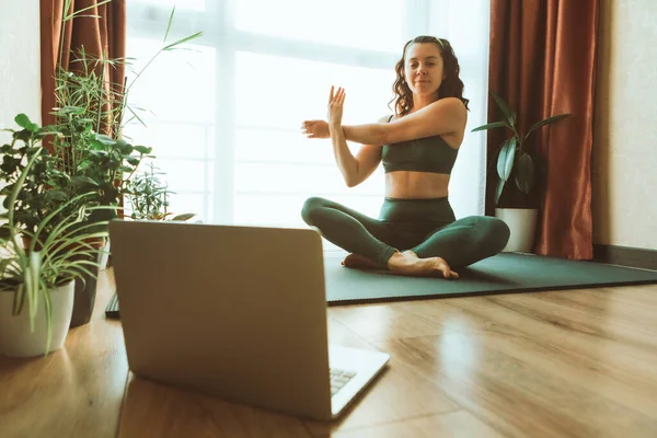 woman do yoga near laptop online learning teaching remotely sport recreation