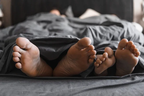 Paar Füße Unter Der Decke Bett Mit Grauen Laken Nahaufnahme — Stockfoto