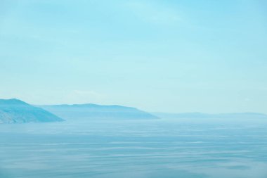 Arka planda dağlar ve mavi gökyüzü olan deniz bölmesi boşluğu kopyala