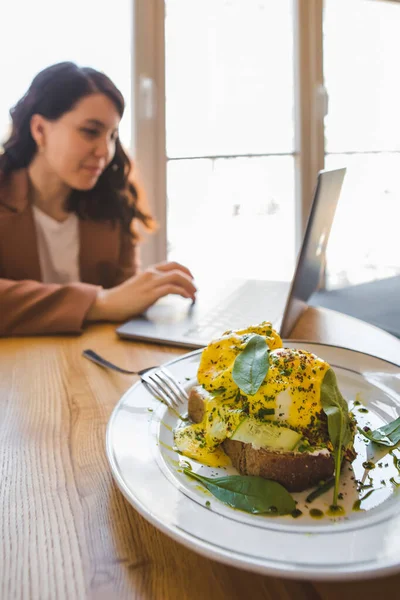 Woman Working Laptop Cafe Eating Fresh Vegetarian Toast Avocado Eggs — Stock Photo, Image