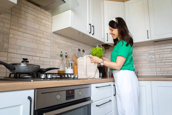 Mulher desmonta compras em casa cozinha — Fotografia de Stock