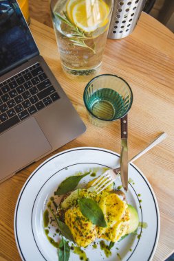 Lokantada avokado ve yumurtalı tost. Kahverengi renkler. Boşluğu kopyala.
