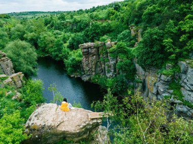 Kadın tepede oturuyor Kanyon nehri ormanının manzarasının tadını çıkarıyor
