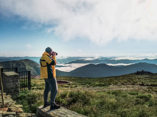 カメラを持ったハイカーマンが山の写真を撮る コピースペース — ストック写真