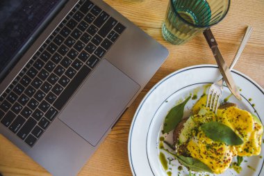 Lokantada avokado ve yumurtalı tost. Kahverengi renkler. Boşluğu kopyala.