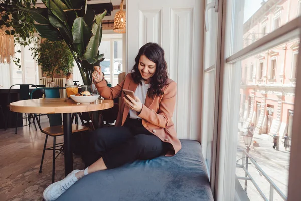Kaunis Nainen Kahvilassa Syöminen Surffaus Internet Puhelimessa Kopioi Tilaa — kuvapankkivalokuva