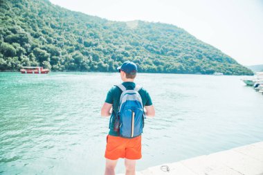 Sırt çantalı bir adam arkadan Sea Bay manzarasına bakıyor. seyahat konsepti. Boşluğu kopyala