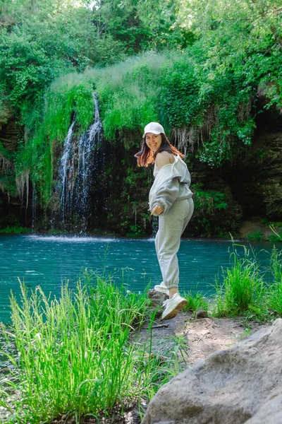 Kadın yürüyüşçü, şelale yaz yolculuğu konseptini zevkle izliyor.