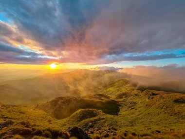 Dağların tepesindeki günbatımının manzarası. Boşluğu kopyala