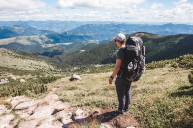 Dağlardaki genç yürüyüşçü. Yaz yürüyüşü yolu. Boşluğu kopyala.