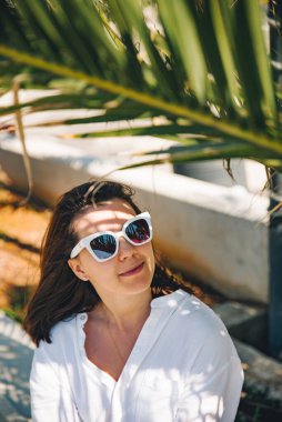 Palmiye yaprağının altındaki güzel kadınların portresi. sıcak gün