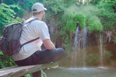 Gezgin gezgin mavi göl kopyalama alanı olan şelaleye bakıyor
