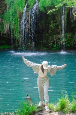 Kadın yürüyüşçü, şelale yaz yolculuğu konseptini zevkle izliyor.