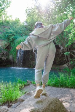 Kadın yürüyüşçü, şelale yaz yolculuğu konseptini zevkle izliyor.