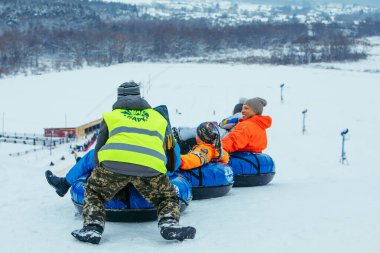 LVIV, UKRAINE - 7 Ocak 2019: kış eğlencesi aktiviteleri. Tepeden aşağıya kar borusuyla git. itme