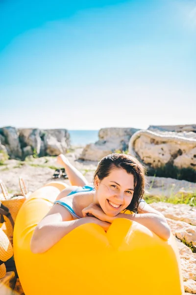 Lächelnde Frau Meeresstrand Auf Gelbem Luftsofa Urlaubskonzept — Stockfoto