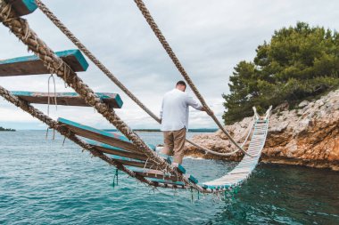 Adam asma köprü üzerinden yürüyor Yaz zamanı kopyalama alanı