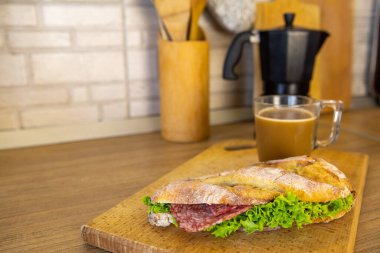 Sabah kahvaltısı sandviçi ve kahve fincanı.