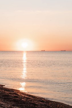 Kumlu deniz sahilinin üzerinde gün doğumunun manzarası. Boşluğu kopyala