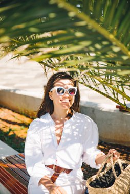 Palmiye yaprağının altındaki güzel kadınların portresi. sıcak gün