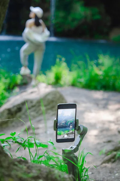 Woman shooting her self on the phone hiker looking at waterfall — Foto de Stock