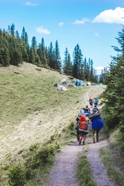 View of hikers group walking by trail in mountains to campsite — Stock Photo, Image