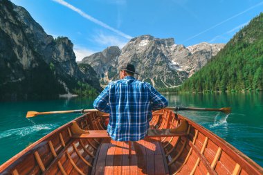 Dağ gölünde sandalda kürek çeken bir adam. kopyalama alanı. yaz tatili
