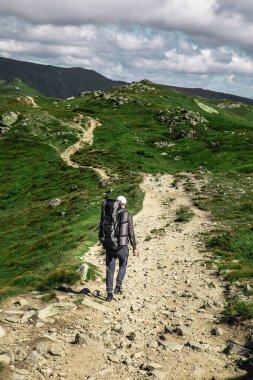 Dağlardaki genç yürüyüşçü. Yaz yürüyüşü yolu. Boşluğu kopyala.