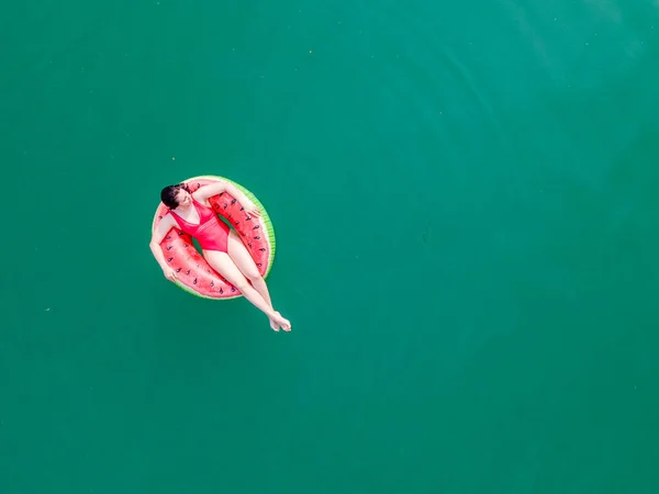 年轻快乐的女人在蓝色的碧蓝的海水中漂浮在充气环状圆环上放暑假 — 图库照片