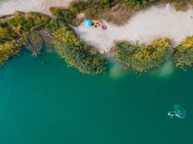 Çiftler kumlu kumsalda güneşlenirken mavi gök mavisi su fotokopi çekerken yaz mevsimi