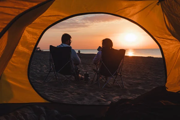 キャンプチェアに座ってコーヒーを飲んで日の出を見ている若い大人のカップル ライフスタイル — ストック写真