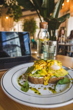 Lokantada avokado ve yumurtalı tost. Kahverengi renkler. Boşluğu kopyala.