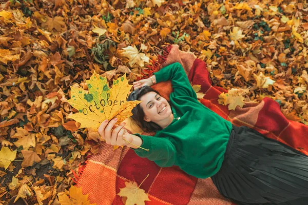 秋天的公园里 一个女人躺在地上的毯子上 梦想的东西 黄叶上的10月文本 — 图库照片