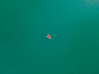 Genç mutlu kadın mavi gökyüzü suyunda yüzüyor şişirilebilir halka yaz tatilinde