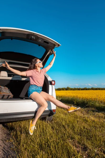 Lächelnde Hübsche Frau Sitzt Kofferraum Eines Geländewagens Bei Sonnenuntergang Und — Stockfoto