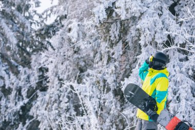 Snowboard kış tatili aktiviteleri yapan kayak ekipmanlı bir adam.