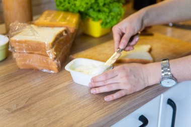 Evdeki mutfakta sabah sandviçi hazırlıyorum.