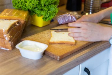Evdeki mutfakta sabah sandviçi hazırlıyorum.