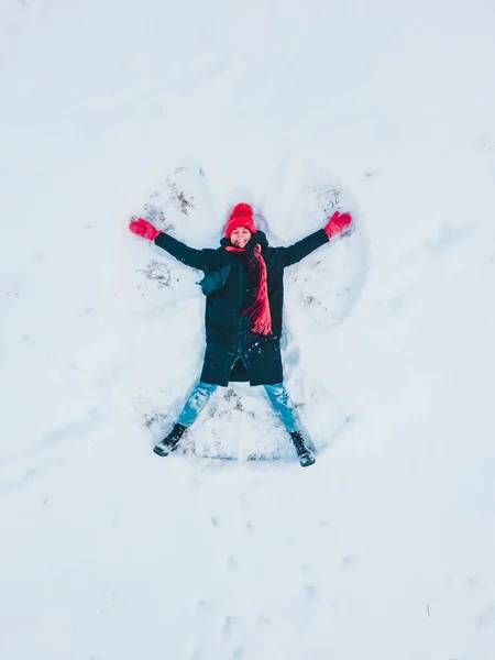 Счастливая Женщина Делает Вид Снежного Ангела Прямо Над Собой — стоковое фото