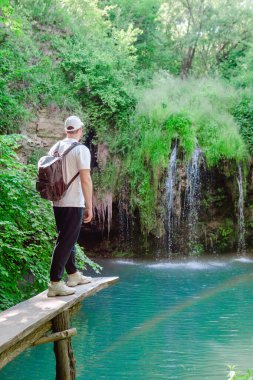 Gezgin gezgin Mavi Göl 'le şelaleye bakıyor