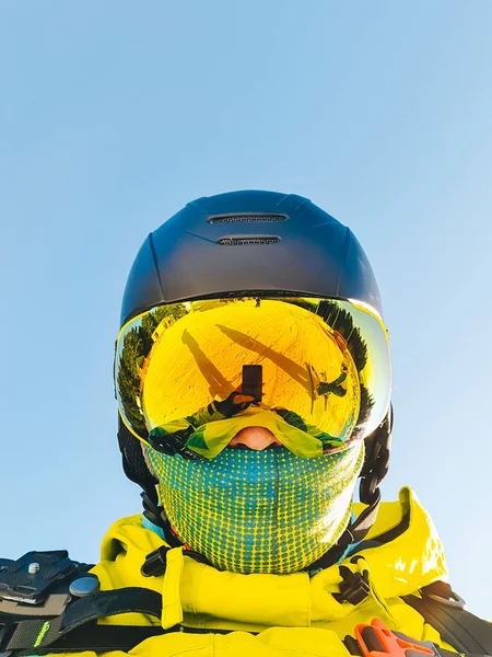 man taking selfie in ski helmet goggles and mask snowboarding