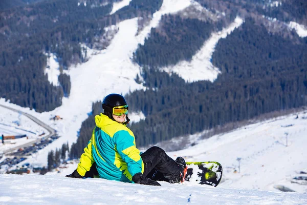 Człowiek Siedzi Snowboardem Szczycie Wzgórza Pięknym Widokiem Skopiować Przestrzeń Słoneczny — Zdjęcie stockowe