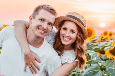 Gün batımında ayçiçeği tarlasında sevimli bir çift. Boşluğu kopyala