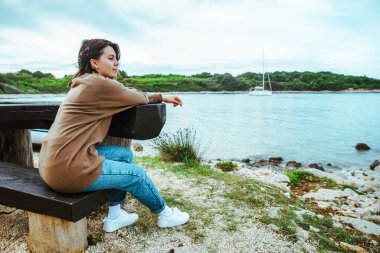 bankta oturan kadın koyda yatta bakıyor. kopyalama alanı