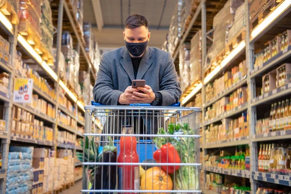Man Grocery Store Cart Checking Phone Copy Space — Stock Photo, Image