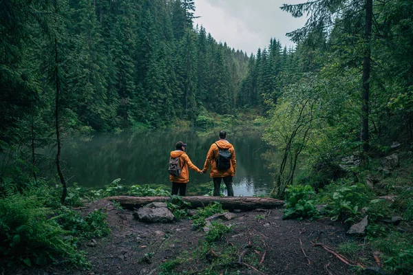 Caminhantes Casal Capa Chuva Amarela Olhando Para Mochileiros Lago Montanha — Fotografia de Stock