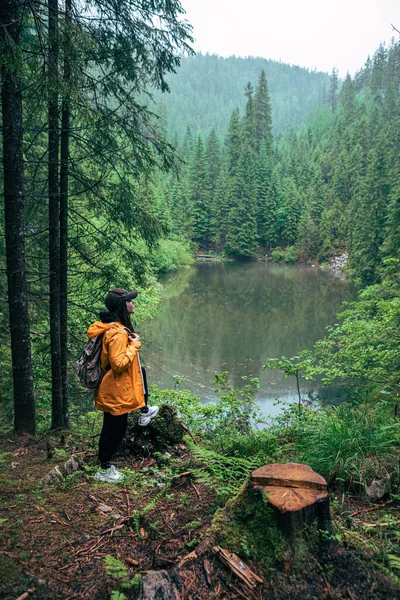 Woman Hiker Backpack Yellow Raincoat Looking Mountain Lake Copy Space — Stock Photo, Image