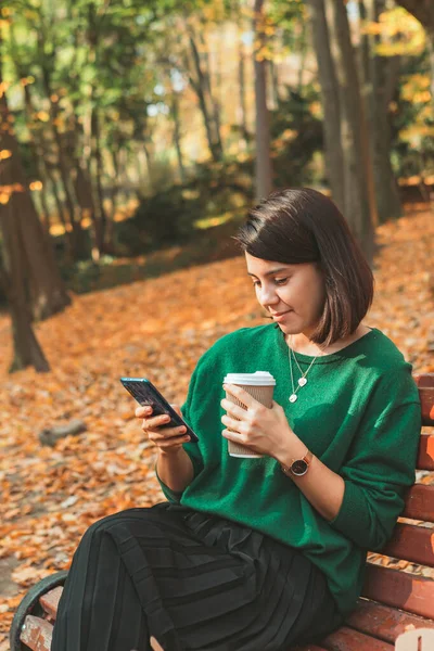 Fiatal Csinos Stílusos Őszi Parkban Kávézás Közben Internetezik Telefonon Másolás — Stock Fotó