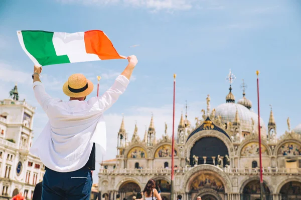 man holding italian fag in rise up hands venice central square san marco copy space
