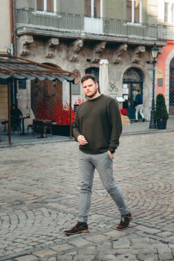 Kazaklı adam şehir meydanındaki fotokopi alanında poz veriyor.